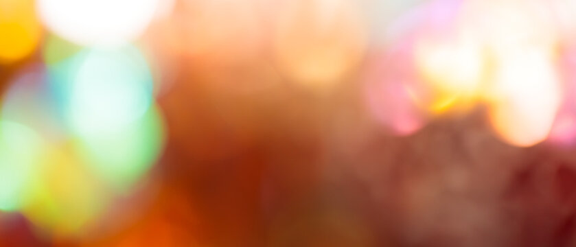 Colorful bokeh light effect with glowing circles on dark warm brown abstract background
