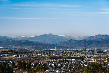 山形村からの眺望 遠くに望む残雪の山々と広がる街並み © kikisora