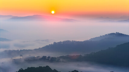 A breathtaking sunrise over a sea of clouds in the highlands, where soft layers of mist drift between rolling hills. The warm glow of the rising sun paints the sky in gentle orange and pink tones © huythoai