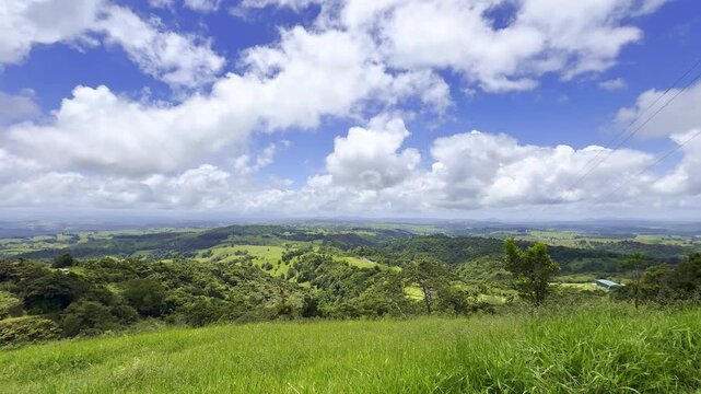Lush green hills and pastures in the Atherton Tablelands near Upper Barron, tropical North Queensland, Australia. Scenic rural landscape with farmland and rolling countryside.