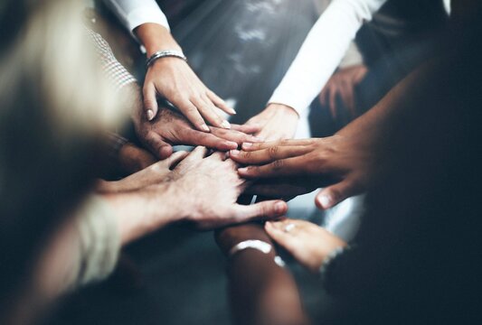 Diverse people joining hands in the middle