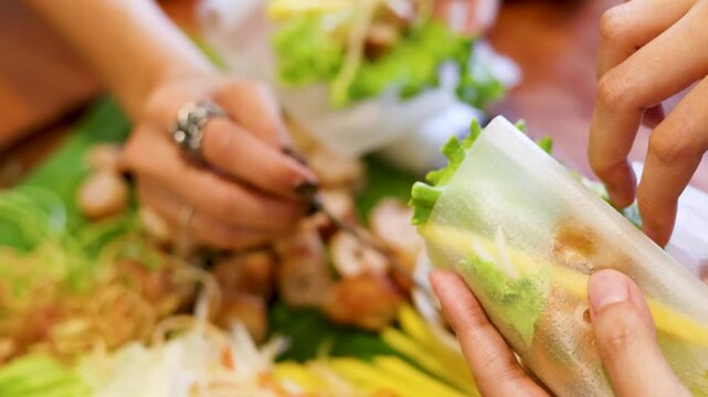 Hands Rolling Fresh Vietnamese Spring Rolls with Rice Paper and Vegetables