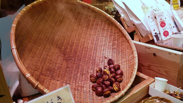 Street Vendor Scooping Roasted Japanese Chestnuts into Paper Bag in Osaka