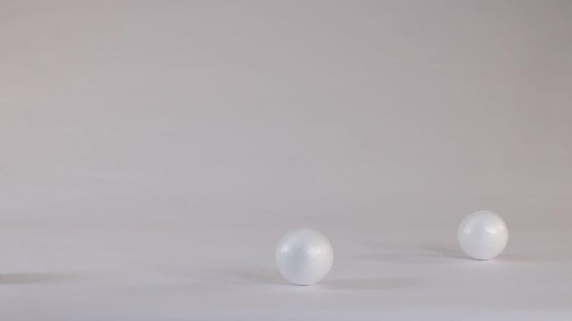 White Polystyrene Foam Balls Bouncing on a Plain Studio Background