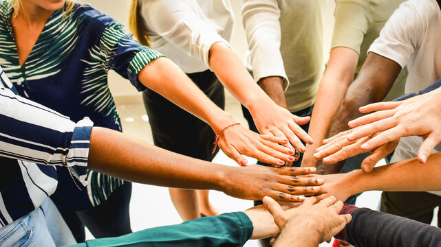 Diverse team joining hands together