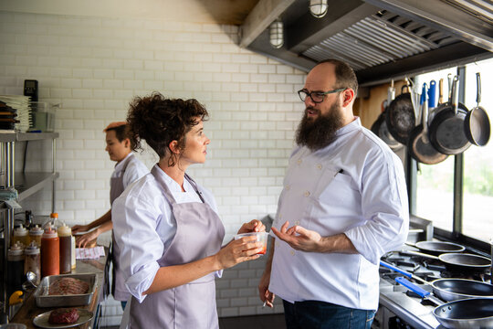 Chefs discussing in modern kitchen
