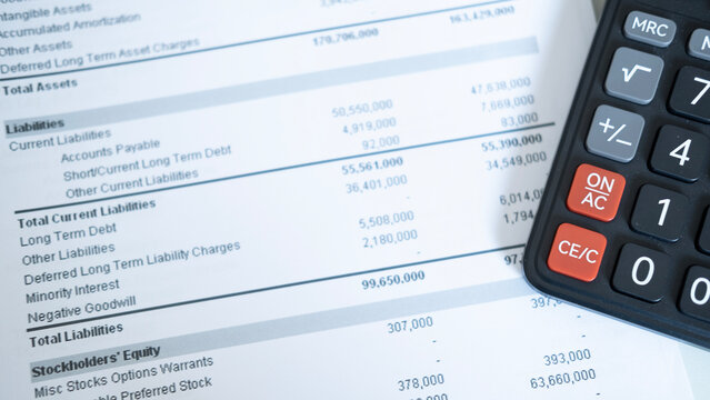 Detailed view of calculator beside financial report on desk, corporate accounting, budget review and expense management concept with clean background.