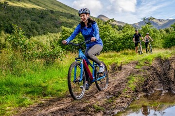 Fototapeta premium Cyclists enjoying muddy trail adventure.