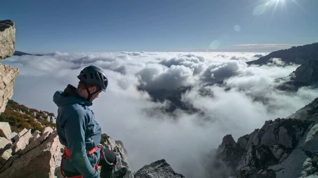 Man standing on mountain peak above clouds adventure and travel concept