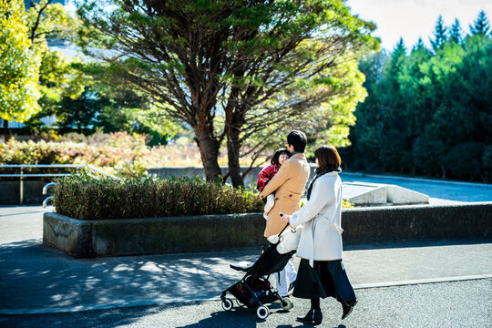 Japanese family enjoying a weekend walk in a beautiful public park with greenery