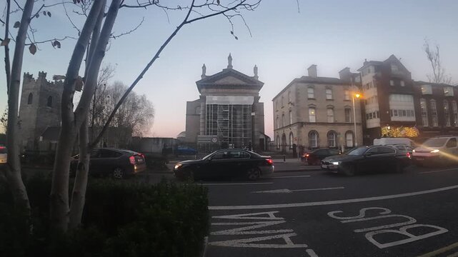 Christ Church Cathedral in Dublin Ireland with evening traffic, cars and historic buildings, urban street scene at dusk showing architecture, transport and city life