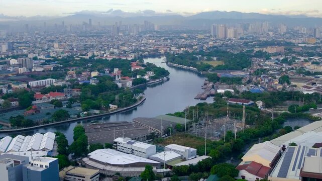 Static aerial view of Pasig River winding through densely populated buildings in capital city Manila Philippines
