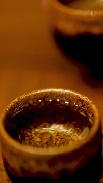 Close Up of Japanese Sake Being Poured into Ceramic Cups in Tokyo