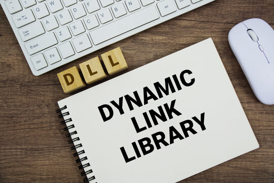 DLL Dynamic Link Library message with keyboard and optical mouse on wooden background
