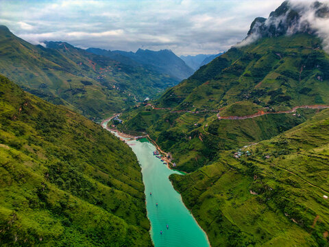 Aerial view of the turquoise Nho Que River flowing through the deep Ma Pi Leng Pass canyon and lush green terraced mountains in the Ha Giang Loop Hoan Kiem, Ha Noi, Vietnam.