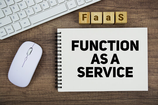 FaaS Function as a Service message with keyboard and optical mouse on wooden background