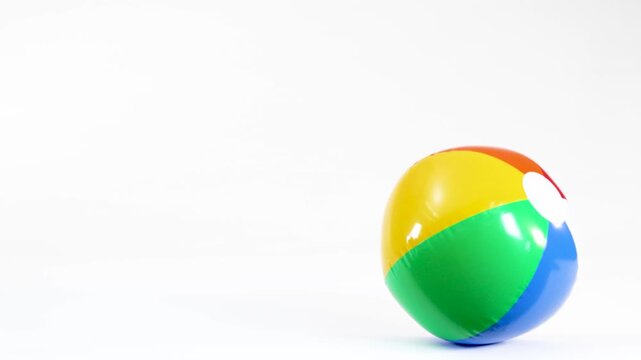 Colorful Inflatable Beach Ball Bouncing and Rolling on White Background