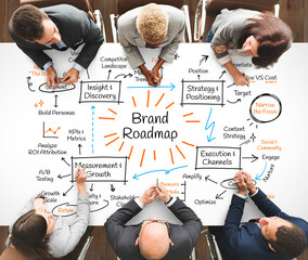 Obraz na płótnie Canvas Top view of diverse team brainstorming a Brand Roadmap on a whiteboard.