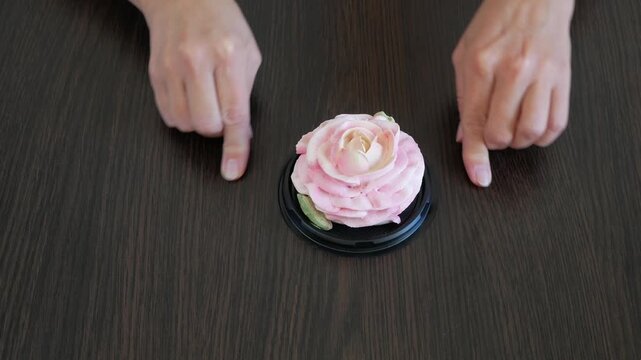 Hands draw a heart on the table around a marshmallow rose flower. Holiday gift. Love.