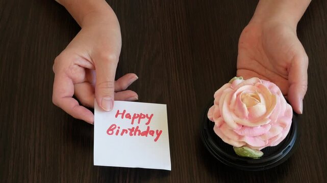 Zefir or marshmallows as pink rose and happy birthday card in hand, Gift box of Zefir, Zephyr and flowers.