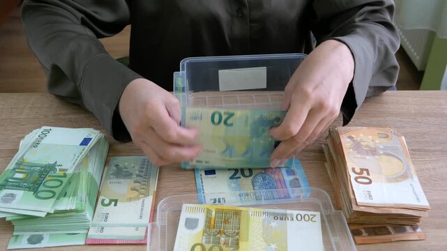 hand counting big stack of euro money on wooden background. money cash, closeup