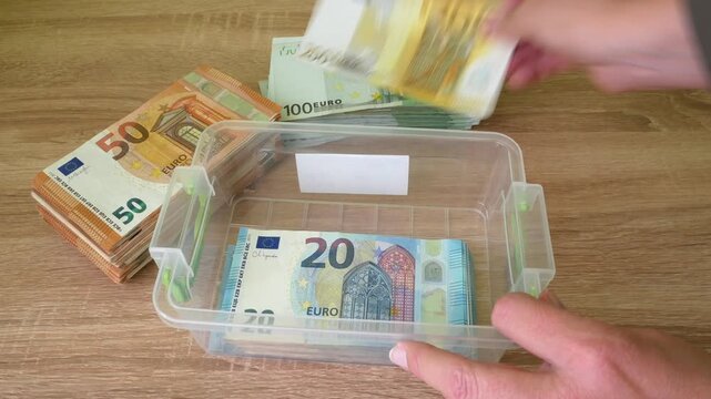 hand counting big stack of euro money on wooden background. money cash, closeup
