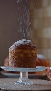 Close up of a homemade cruffin being dusted with a powdered sugar