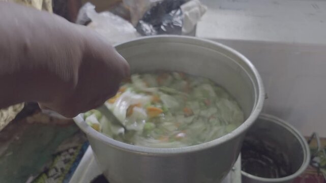 Stirring Vegetable Soup with Potato Carrot and Cabbage in Boiling Pot