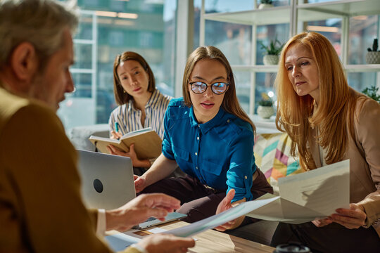 Diverse business team collaborating on project during meeting