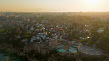 Obraz premium Antalya, Turkey. Aerial drone view of Hidirlik Tower integrated with Kaleici Old Town architecture and narrow streets in warm morning light.. Aerial View