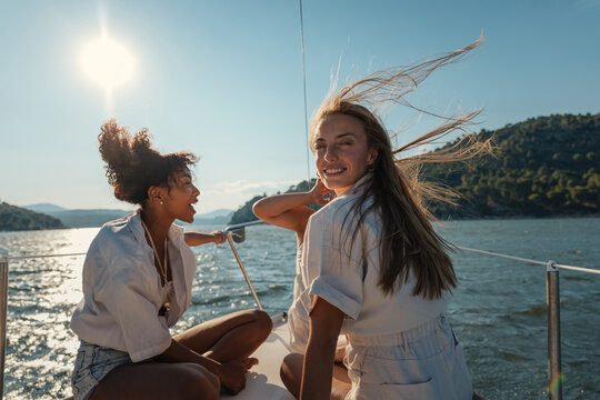 Cheerful young women enjoying a sailing trip on ocean