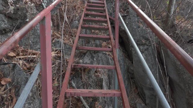 POV climbing unsafe stairs in the jungle up a karst limestone mountain with questionable welds and build quality.