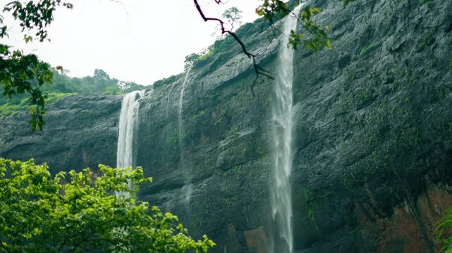 4K Landscape shot of Kataldhar waterfall flowing from a mountain cliff during the monsoon season in the Sahyadri hills near Lonavala in Maharashtra, India. Scenic view of waterfall in monsoon.