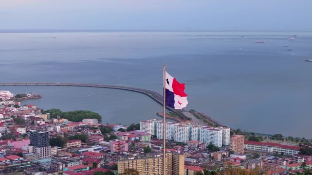 Aerial drone shot of the Panama flag with the city and the Amador Causeway in the background