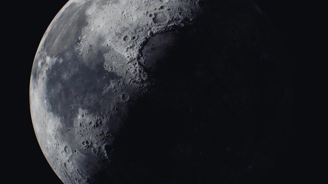 A close up view of the moon during its crescent phase, showcasing detailed craters and surface texture under bright sunlight.