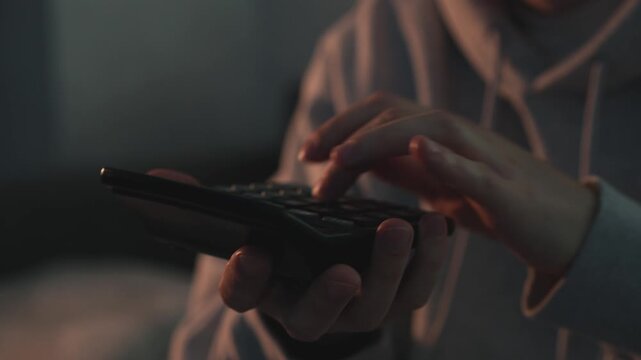 Close-up of an accountant working with a calculator, analyzing financial data in a dimly lit room. Concept of business calculations, budgeting, tax planning, and economic analysis