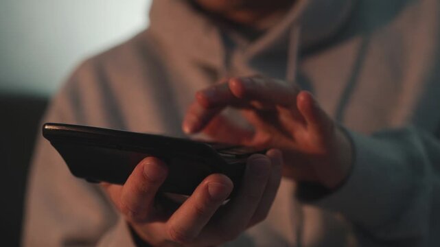 Close-up of hands of a financial professional using a calculator to process numbers in a dark office environment. Concept of business planning, financial management, and economic decision making.
