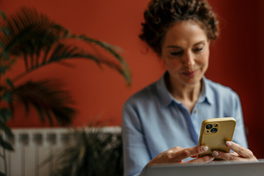 Woman working remotely using phone for communication