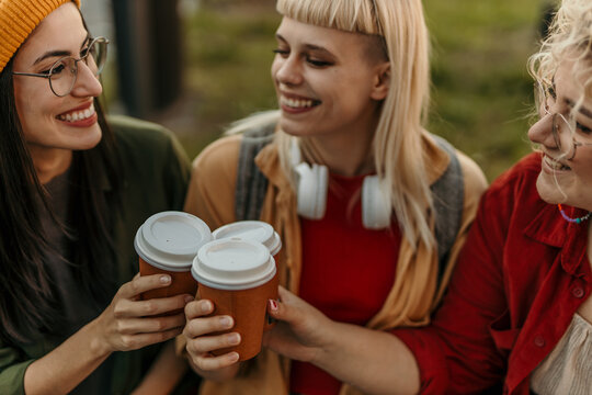Happy young women enjoying coffee and friendship outdoors