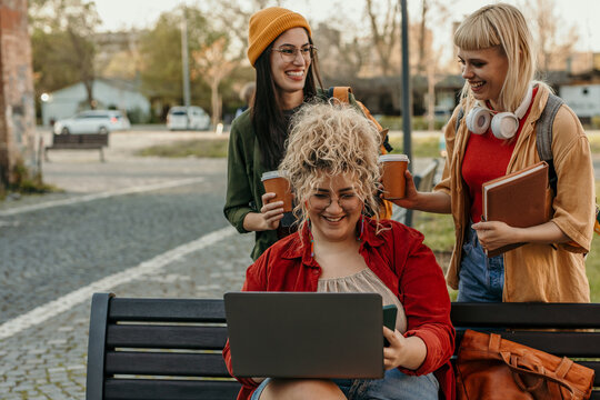 Diverse students enjoying campus life with coffee and laptop