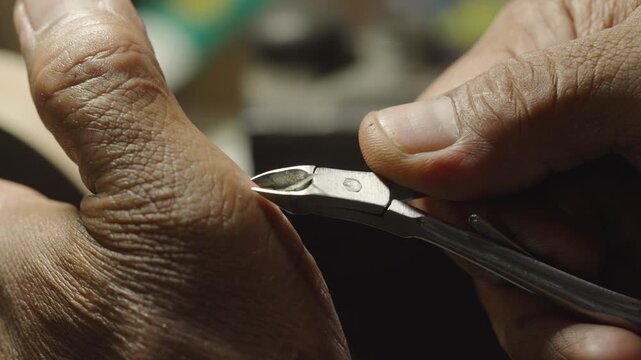 Craftsman testing sharpness of nipper on palm carefully in workshop