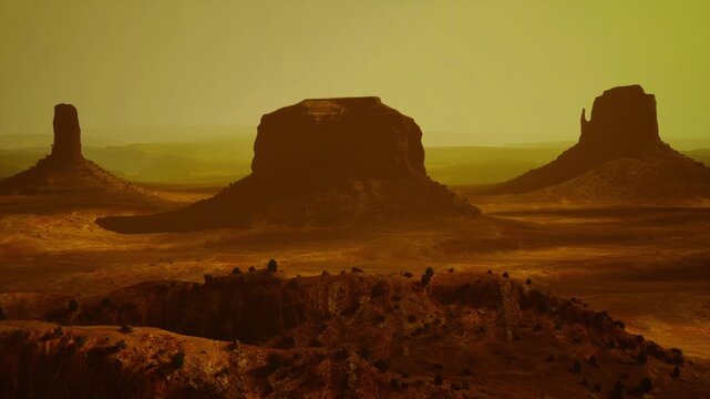 Amber desert mesas under hazy golden sky, iconic silhouettes and ochre cliffs evoke western nostalgia, ideal for travel editorial and sunset campaigns.