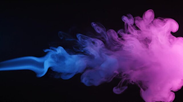 Vibrant blue and fuchsia smoke plumes elegantly intertwine and diffuse, crafting a captivating abstract visual against a dark backdrop, symbolizing dynamic energy and creative flow