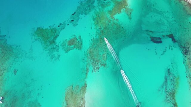 Two jet skis speed across the turquoise Balos Lagoon, Crete, leaving long white wakes. A cinematic horizontal shot capturing summer adventure in a Mediterranean paradise. High quality 4k footage