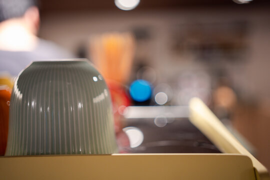 Green ceramic coffee cups lie upside down on a coffee machine in a cafe