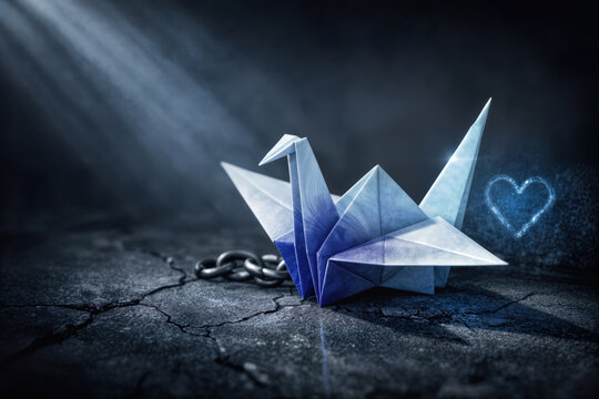 World Day Against Trafficking in Persons Blue Heart Campaign origami crane on cracked concrete with broken chain symbolizing human trafficking awareness dignity protection July 30