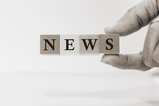 Hand holding wooden blocks spelling news concept