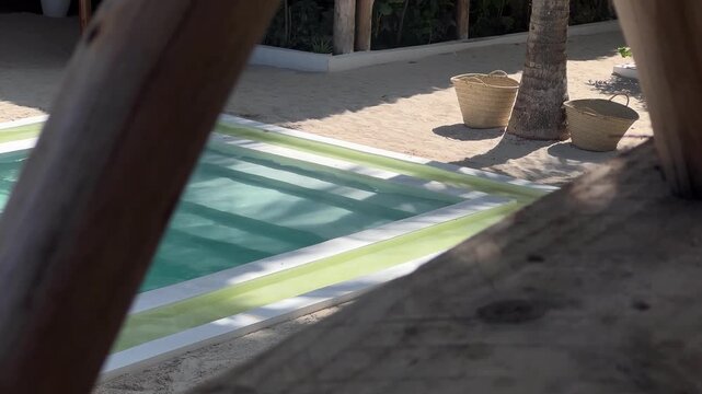 Luxury tropical pool with palm shadows on water surface, resort background Zanzibar