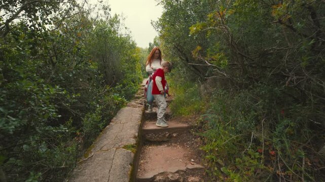 Mother and son descending a forest path