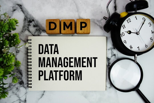 DMP Data Management Platform text with alarm clock and magnifying glass on marble background